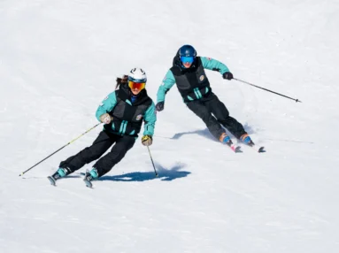 Schüler folgt dem Skitrainer auf der Piste
